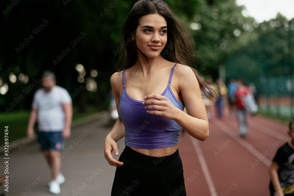Happy athletic woman running in nature in the morning. Young woman training outdoors...