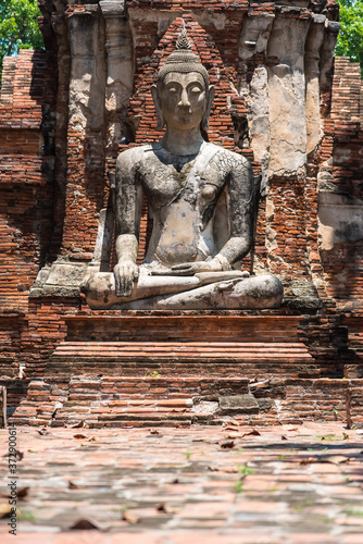 Ayutthaya, Thailand - June, 22, 2020 : Old Buddha statue sitting on brick in Wat Yai Chai Mongkhol temple, Ayutthaya, Thailand photo