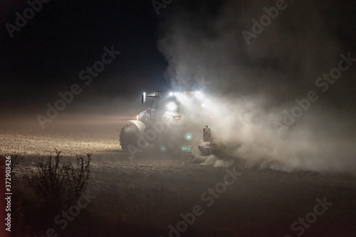 Traktor bestellt ein Feld in der Nacht