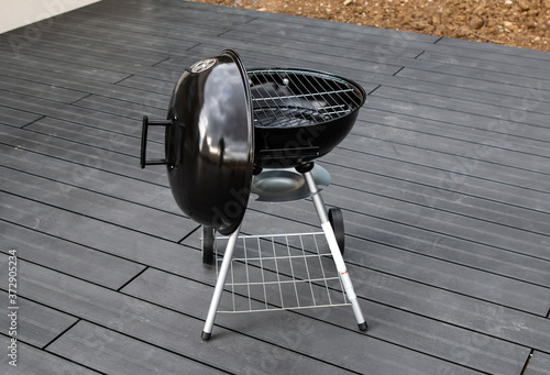 Black barbecue grill isolated on the terrace with composite