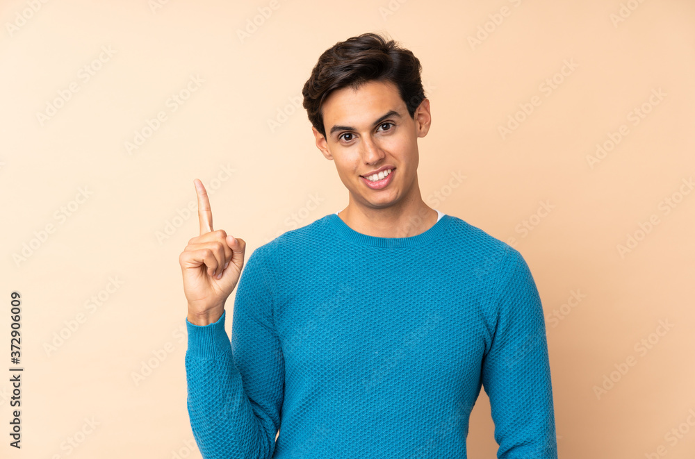 Man over isolated background showing and lifting a finger in sign of the best Man over isolated background showing and lifting a finger in sign of the best