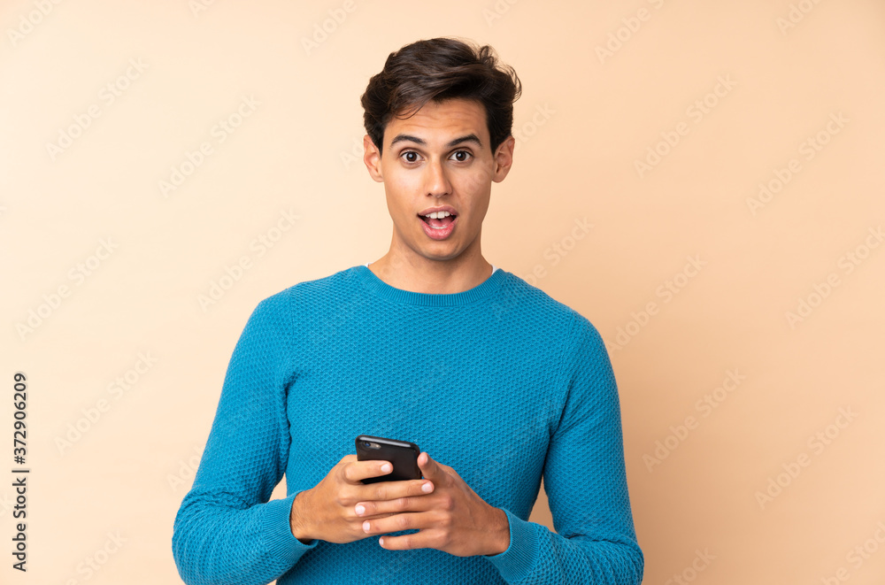 Man over isolated background surprised and sending a message Man over isolated background surprised and sending a message
