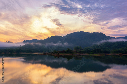 Beautiful landscape morning with rising sun on lake at Hat Som Paen