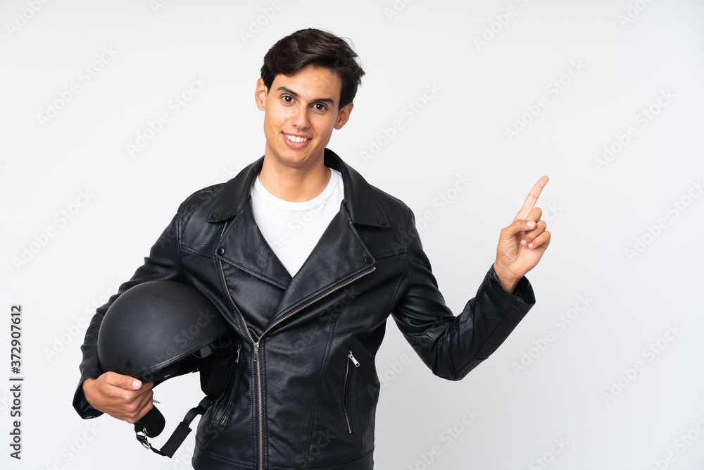 Man holding a motorcycle helmet over isolated white background pointing finger to the side Man holding a motorcycle helmet over isolated white background pointing finger to the side