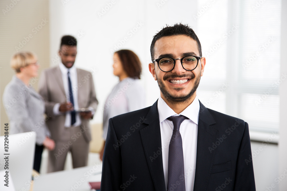 Portrait of arab businessman and his colleagues on the background at the office Portrait of arab businessman and his colleagues on the background at the office