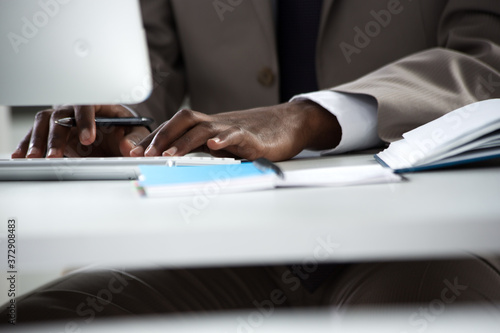 Close-up of hands of african-american businessman typing on a keyboard.