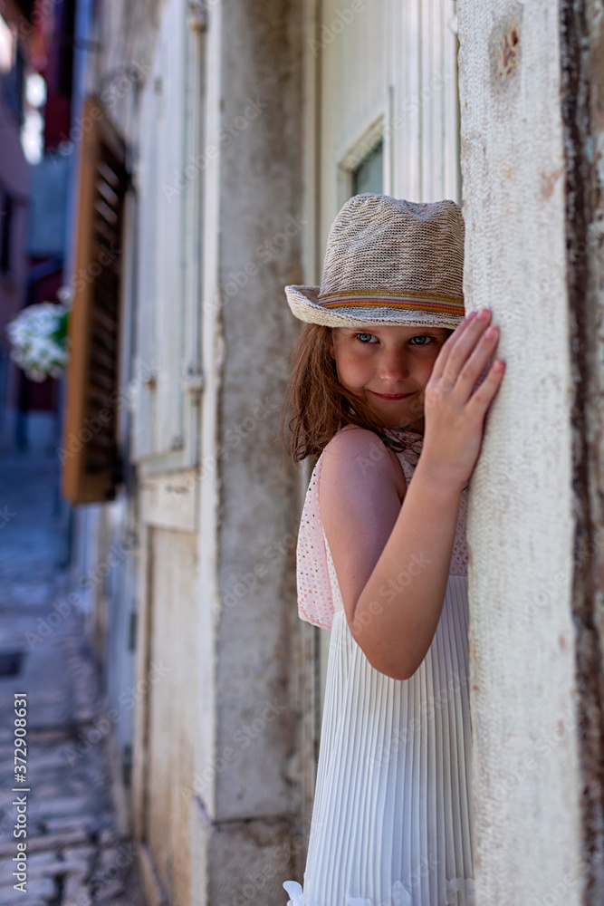 Funny little girl standing in the street of old mediterranean town of Rovinj, Croatia.