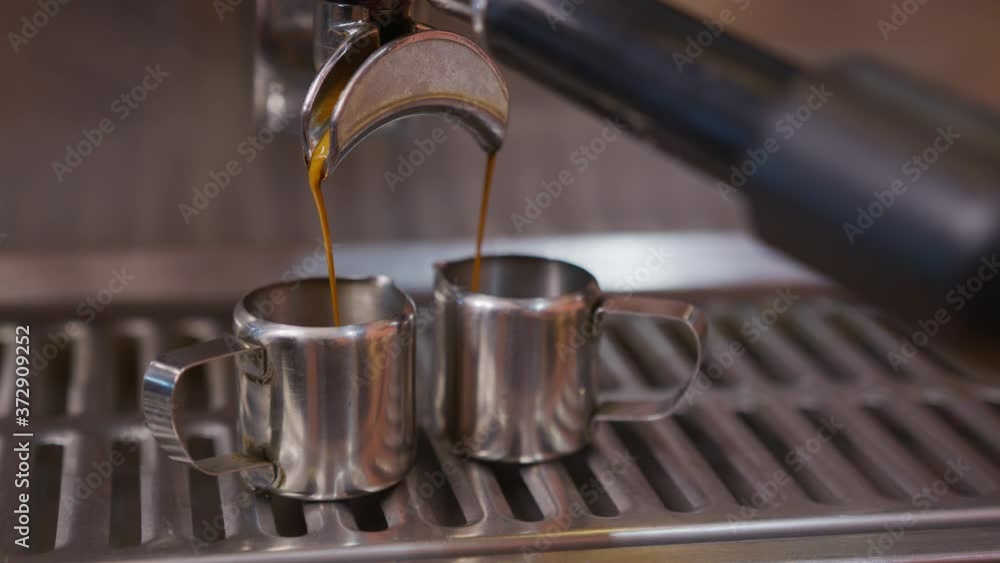 Close-up of espresso from coffee machine. Professional barista coffee brewing in coffee shop. Close-up of espresso from coffee machine. Professional barista coffee brewing in coffee shop.