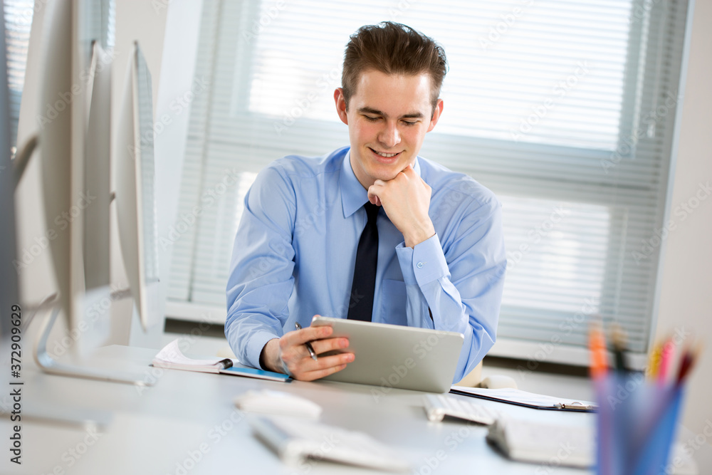 Portrait of young businessman working with tablet computer at office Portrait of young businessman working with tablet computer at office