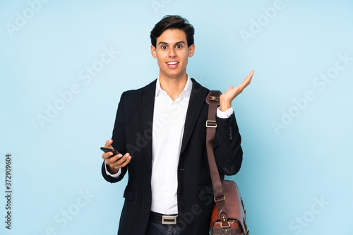 Businessman over isolated blue background with surprise facial expression