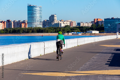 Woman riding a road bike along the embankment