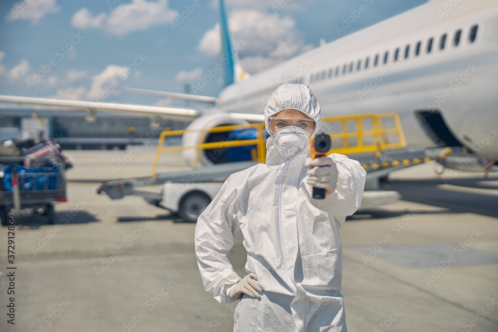 Woman in sterile gloves taking passenger temperature Woman in sterile gloves taking passenger temperature