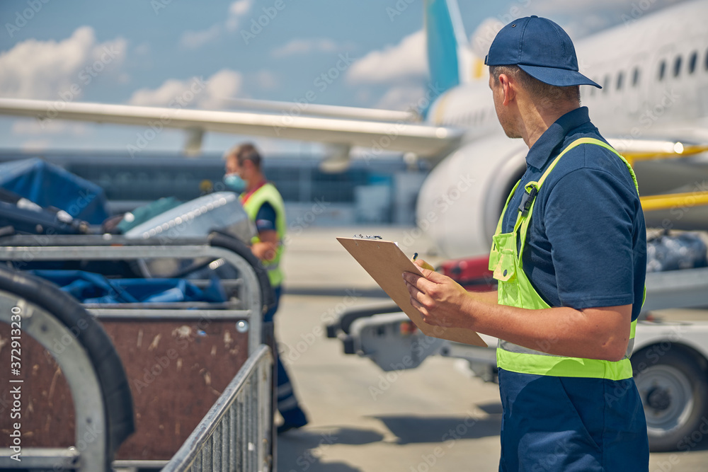 Man looking at a working baggage handler Man looking at a working baggage handler