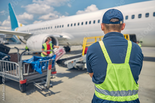 Baggage handlers loading suitcases onto an airplane photo