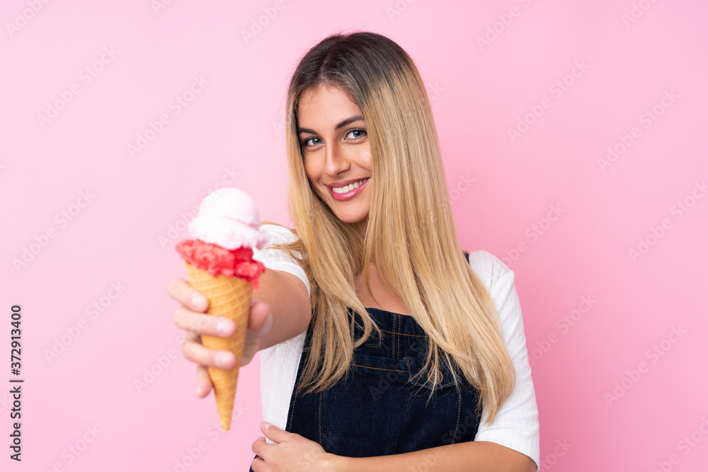 Young Uruguayan woman with a cornet ice cream over isolated pink background Young Uruguayan woman with a cornet ice cream over isolated pink background
