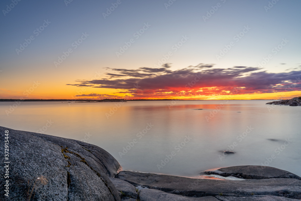 Long exposure of a summer sunset in the archipelago with silky smooth water.