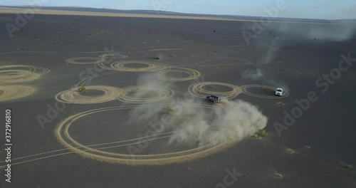 car draws circles in the sand drift in the desert