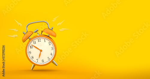Termindruck – Klingelnder Wecker auf gelben Hintergrund photo