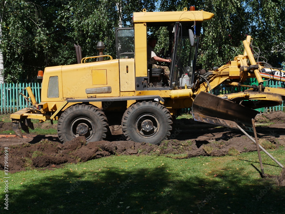 yellow bulldozer at construction site. construction work to repair the road. In the village. Dug-up road