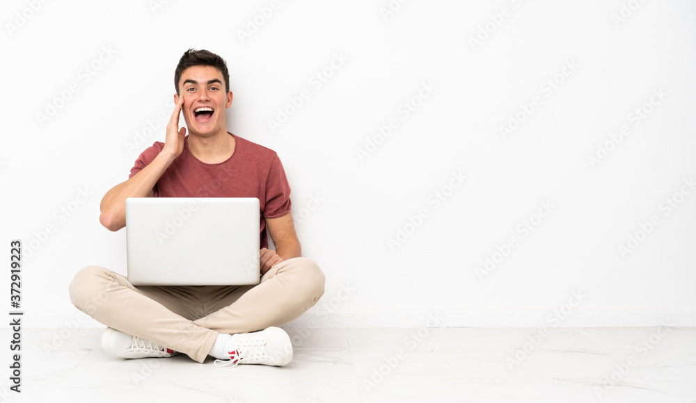 Teenager man sitting on the flor with his laptop with surprise and shocked facial expression Teenager man sitting on the flor with his laptop with surprise and shocked facial expression