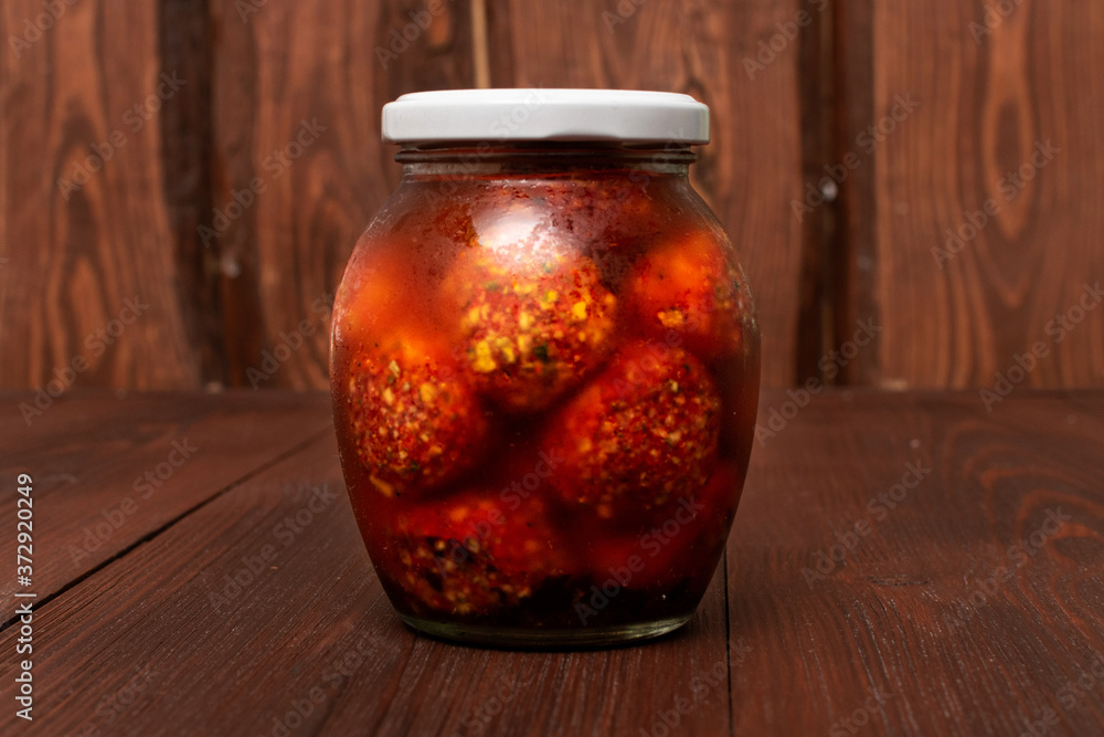 Mix of vegetables canned in a jar on a wooden background. Mix of vegetables canned in a jar on a wooden background.