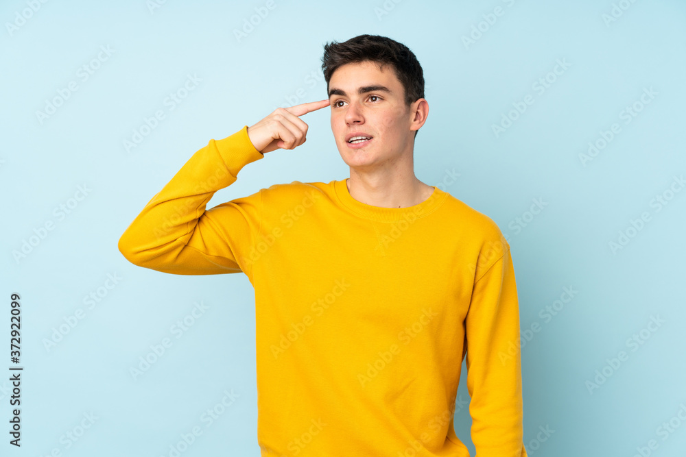 Teenager caucasian handsome man isolated on purple background making the gesture of madness putting finger on the head Teenager caucasian handsome man isolated on purple background making the gesture of madness putting finger on the head