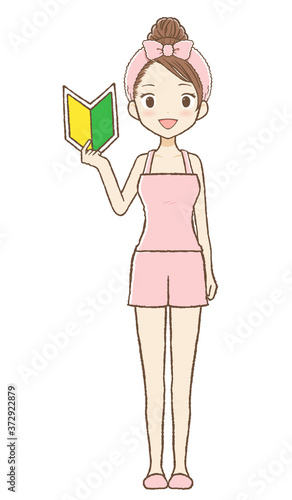ルームウエアを着た女性が若葉マークを持っている

