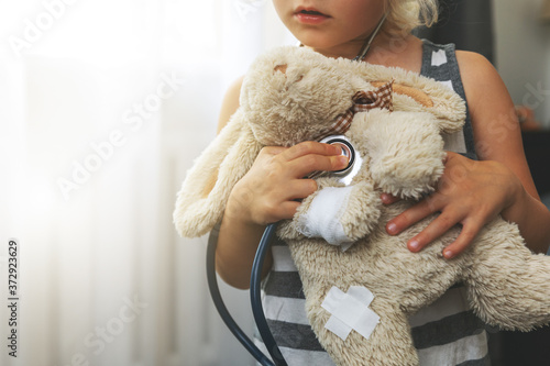 Fotografia child playing doctor with soft toy