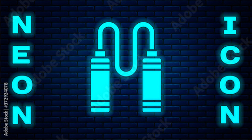 Glowing neon Jump rope icon isolated on brick wall background. Skipping rope. Sport equipment. Vector.