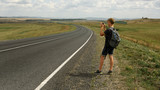 A young man takes pictures on a phone landscape next to a country road