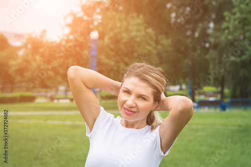 Image of beautiful middle-aged woman laughing in summer park © bisonov