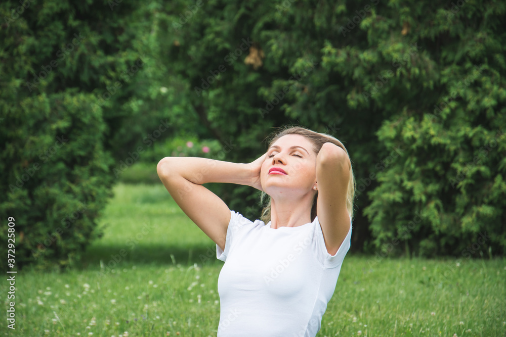 Image of beautiful middle-aged woman laughing in summer park Image of beautiful middle-aged woman laughing in summer park