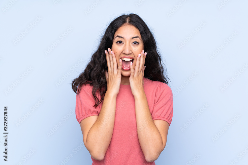 Mixed race woman wearing a sweater over isolated blue background with surprise facial expression Mixed race woman wearing a sweater over isolated blue background with surprise facial expression