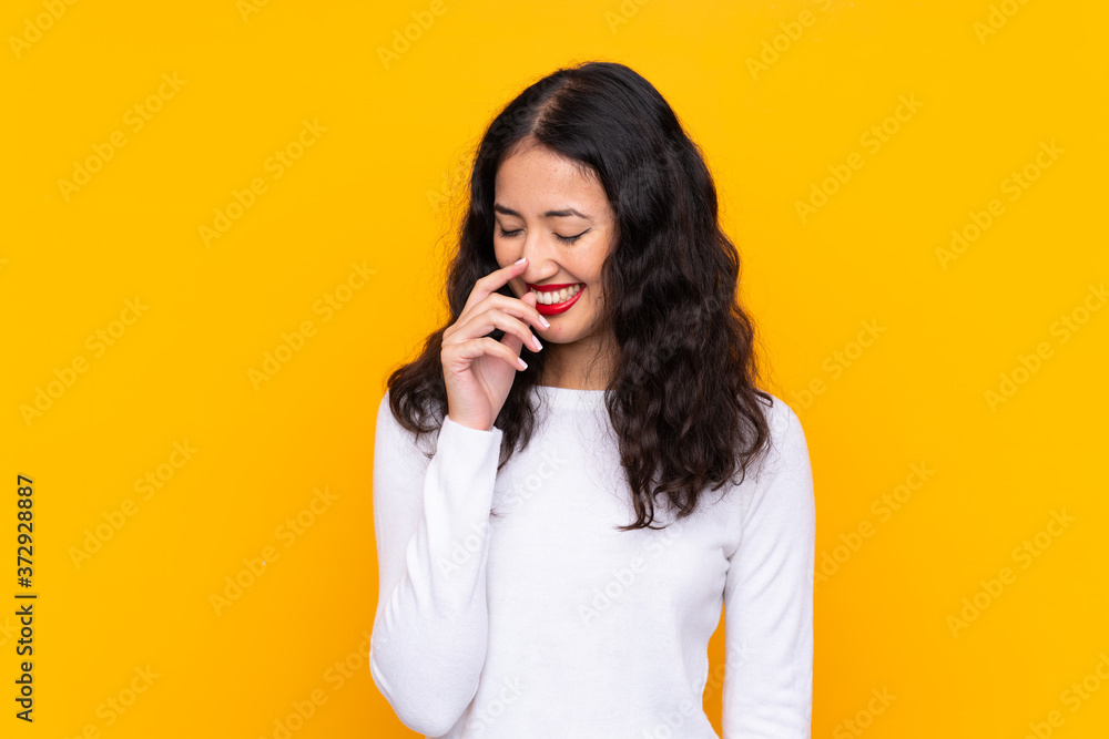 Fototapeta premium Mixed race woman over isolated yellow background laughing
