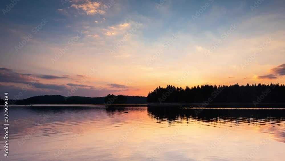 Timelapse with beautiful sunset view of а mountain lake and clear sky with the setting sun, at Shiroka Polyana dam in Rhodope Mountains, Bulgaria Timelapse with beautiful sunset view of а mountain lake and clear sky with the setting sun, at Shiroka Polyana dam in Rhodope Mountains, Bulgaria