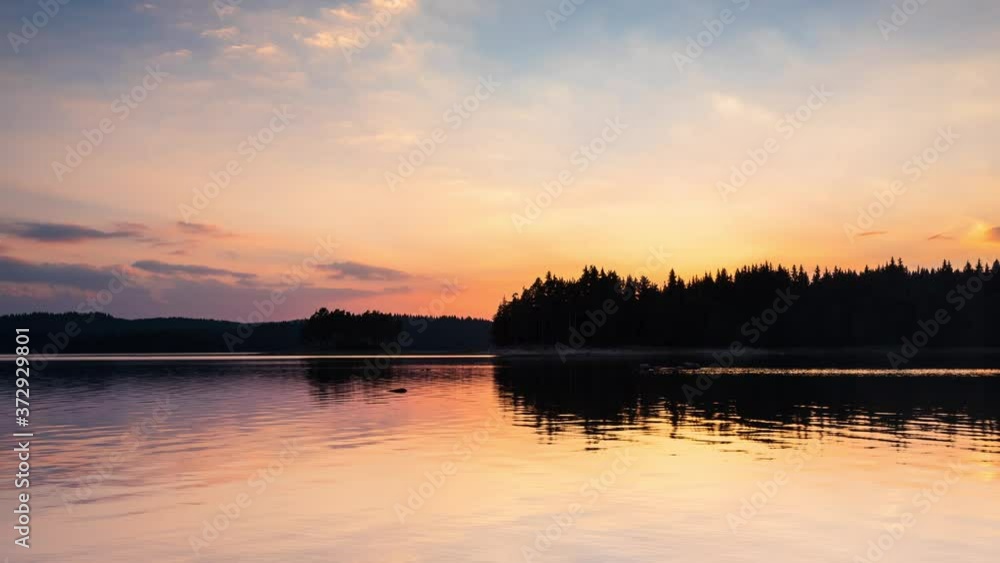 Timelapse with beautiful sunset view of а mountain lake and clear sky with the setting sun, at Shiroka Polyana dam in Rhodope Mountains, Bulgaria Timelapse with beautiful sunset view of а mountain lake and clear sky with the setting sun, at Shiroka Polyana dam in Rhodope Mountains, Bulgaria