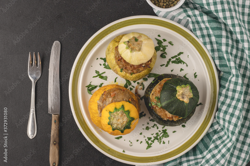 Vegetarian stuffed round zucchinis with vegetables, top view, flat lay. Served and ready to eat.