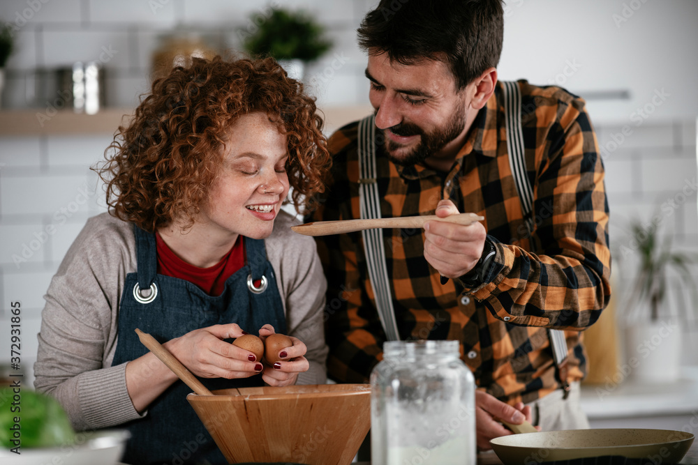 Boyfriend and girlfriend making delicious food at home. Loving couple cooking in kitchen.. Boyfriend and girlfriend making delicious food at home. Loving couple cooking in kitchen..