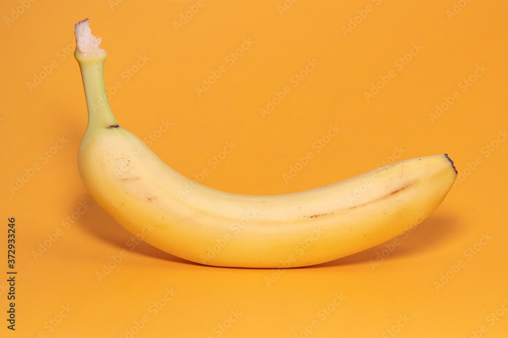 Single banana against yellow background Single banana against yellow background
