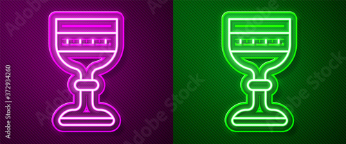 Glowing neon line Medieval goblet icon isolated on purple and green background. Vector.