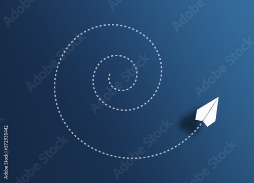 top view of paper plane flying spiral path against blue background, going around in circles concept