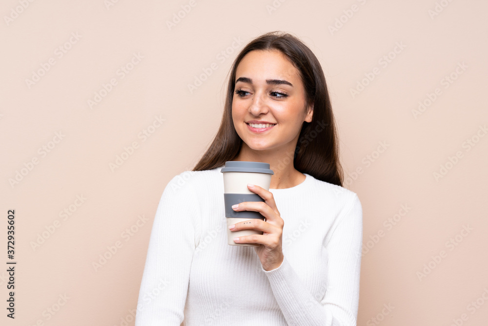 Young woman over isolated background holding coffee to take away Young woman over isolated background holding coffee to take away