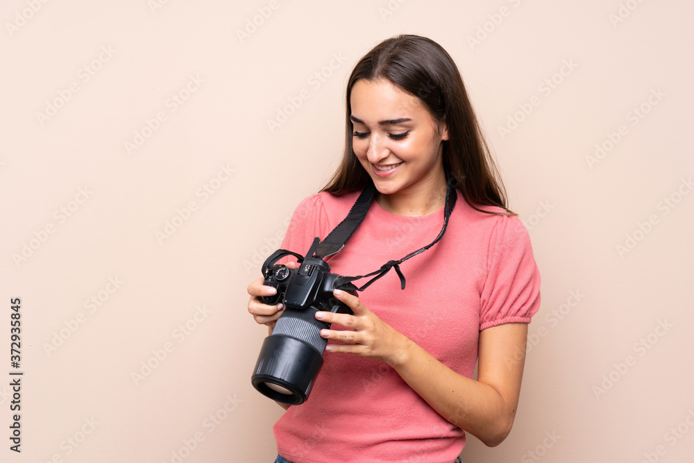 Young woman over isolated background with a professional camera Young woman over isolated background with a professional camera