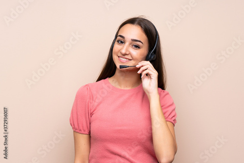 Young woman over isolated background working with headset