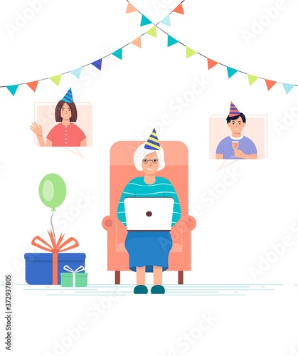 Online meeting with family. Grandchildren wish their grandmother happy birthday online. An elderly woman with a laptop in a chair accepts birthday greetings. Online communication concept.