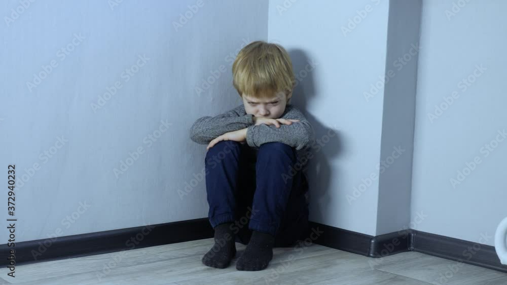 Domestic violence concept. sad lifestyle upset boy sitting in corner. Child punished sitting crying in the corner. Child abuse Domestic violence concept. sad lifestyle upset boy sitting in corner. Child punished sitting crying in the corner. Child abuse