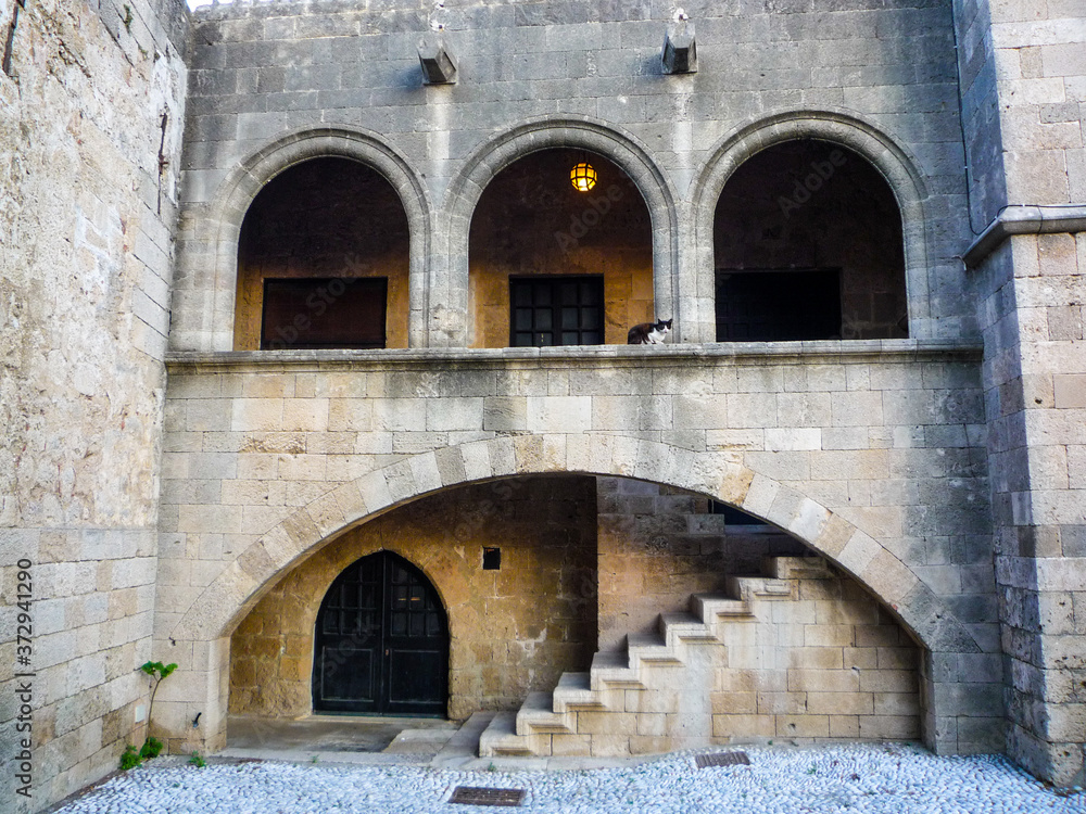 stone architecture building with oval arches doors steps and staircase in rhodes