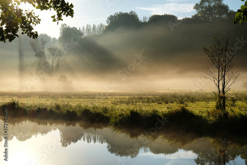 Early morning mist over the meadows on the River Wey in Godalming, Surrey, on a cold autumn morning.