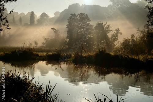 Early morning mist over the meadows on the River Wey in Godalming, Surrey, on a cold autumn morning.