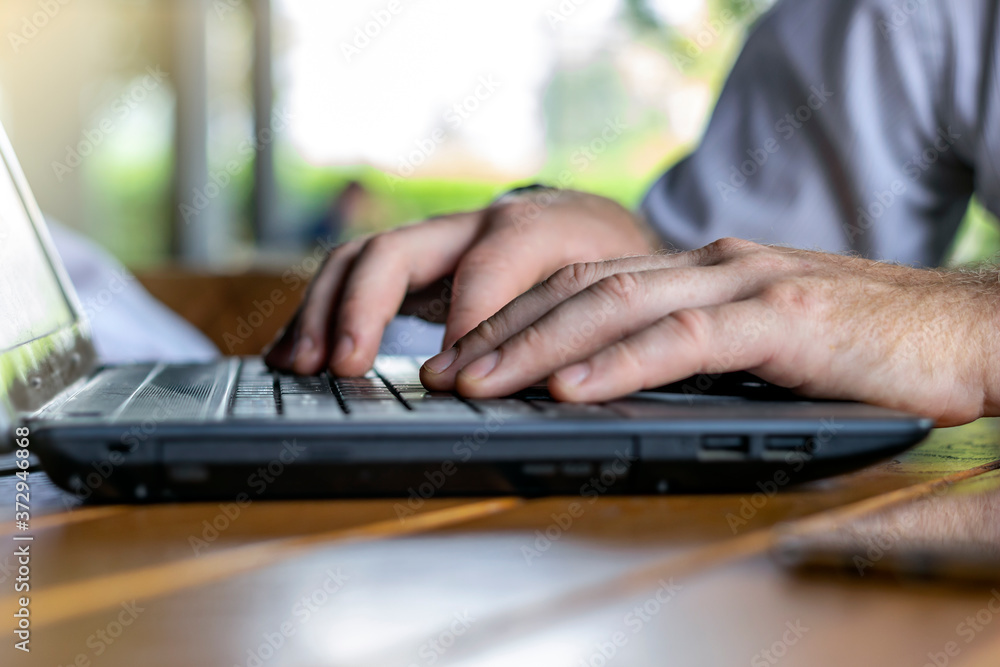 Photo of hands of a businessman on keyboard.Businessman working with laptop on table.Close-up of typing male hands.Businessman using smartphone and laptop computer.Man working on laptop at the office. Photo of hands of a businessman on keyboard.Businessman working with laptop on table.Close-up of typing male hands.Businessman using smartphone and laptop computer.Man working on laptop at the office.